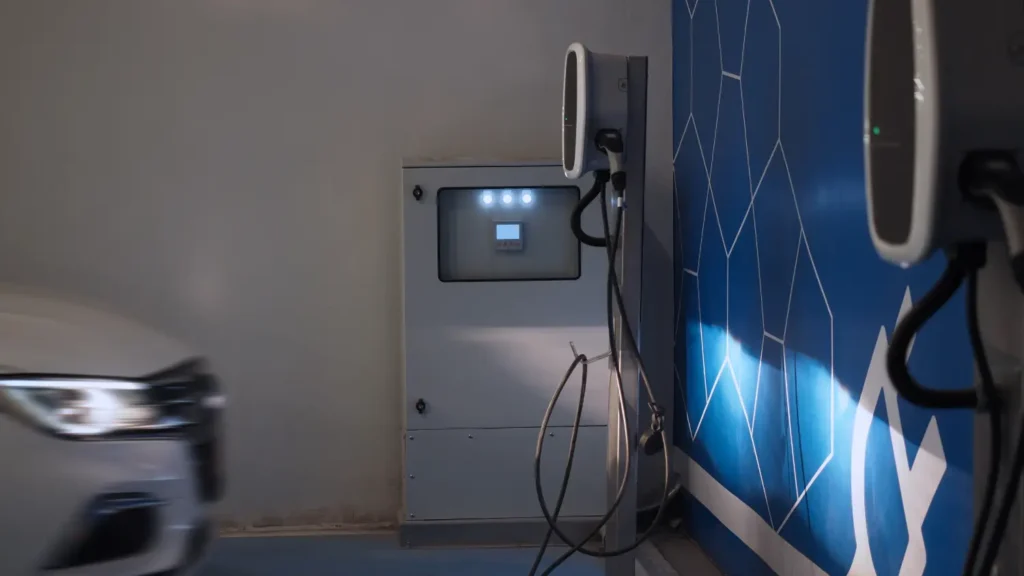 Electric vehicle parked beside a Level 2 charging station in a home garage