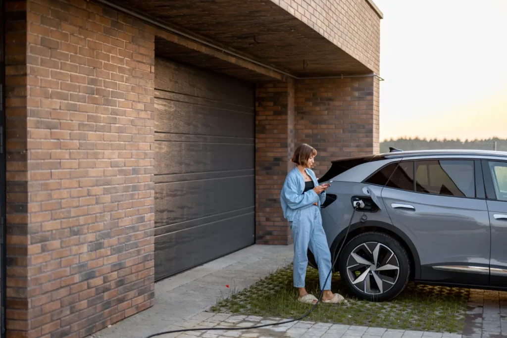 Homeowner plugging in her electric SUV to a home EV charger in the driveway